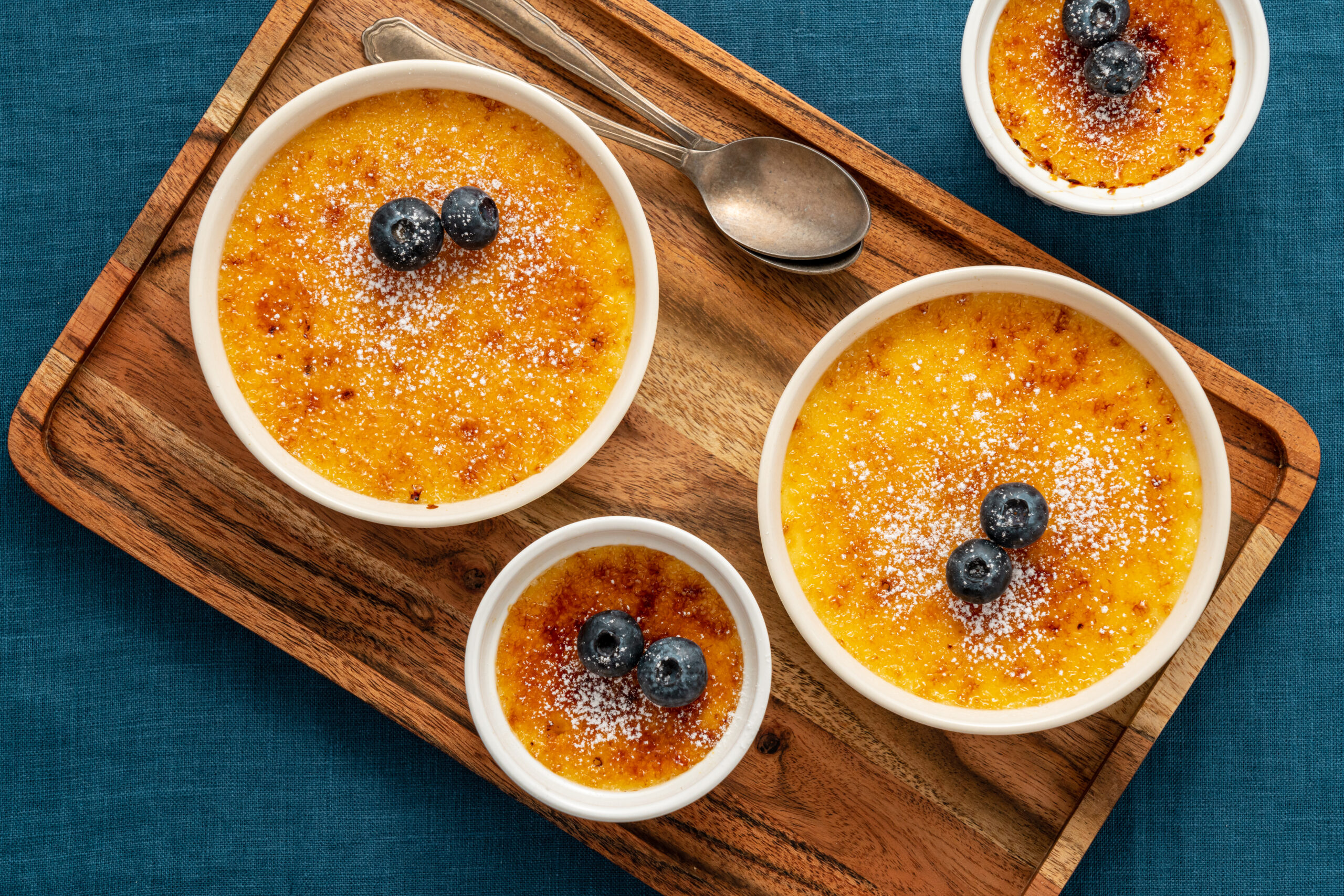 Crema catalana with blueberries on a wooden tray