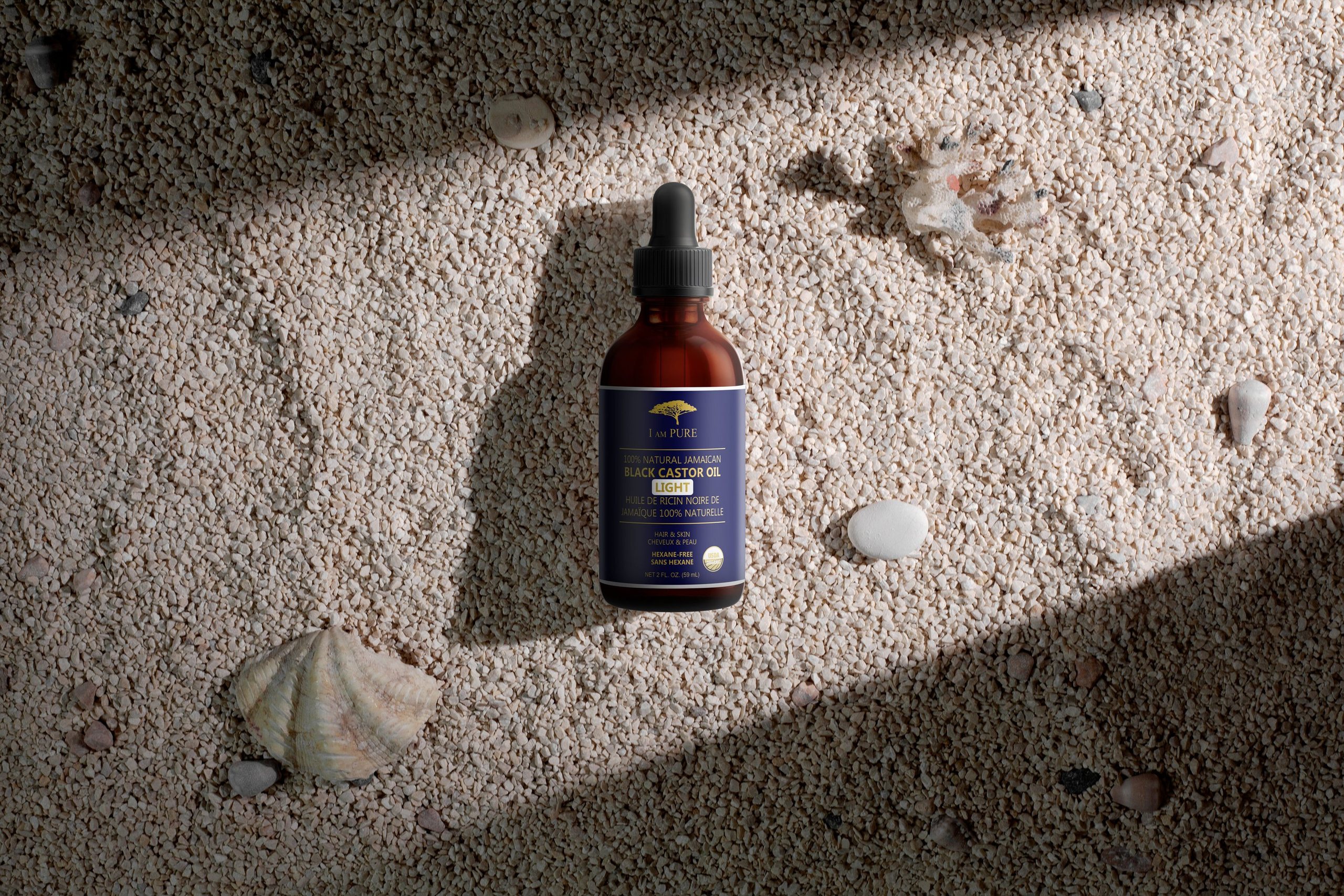 IAMPURE bottle on sand in raking light