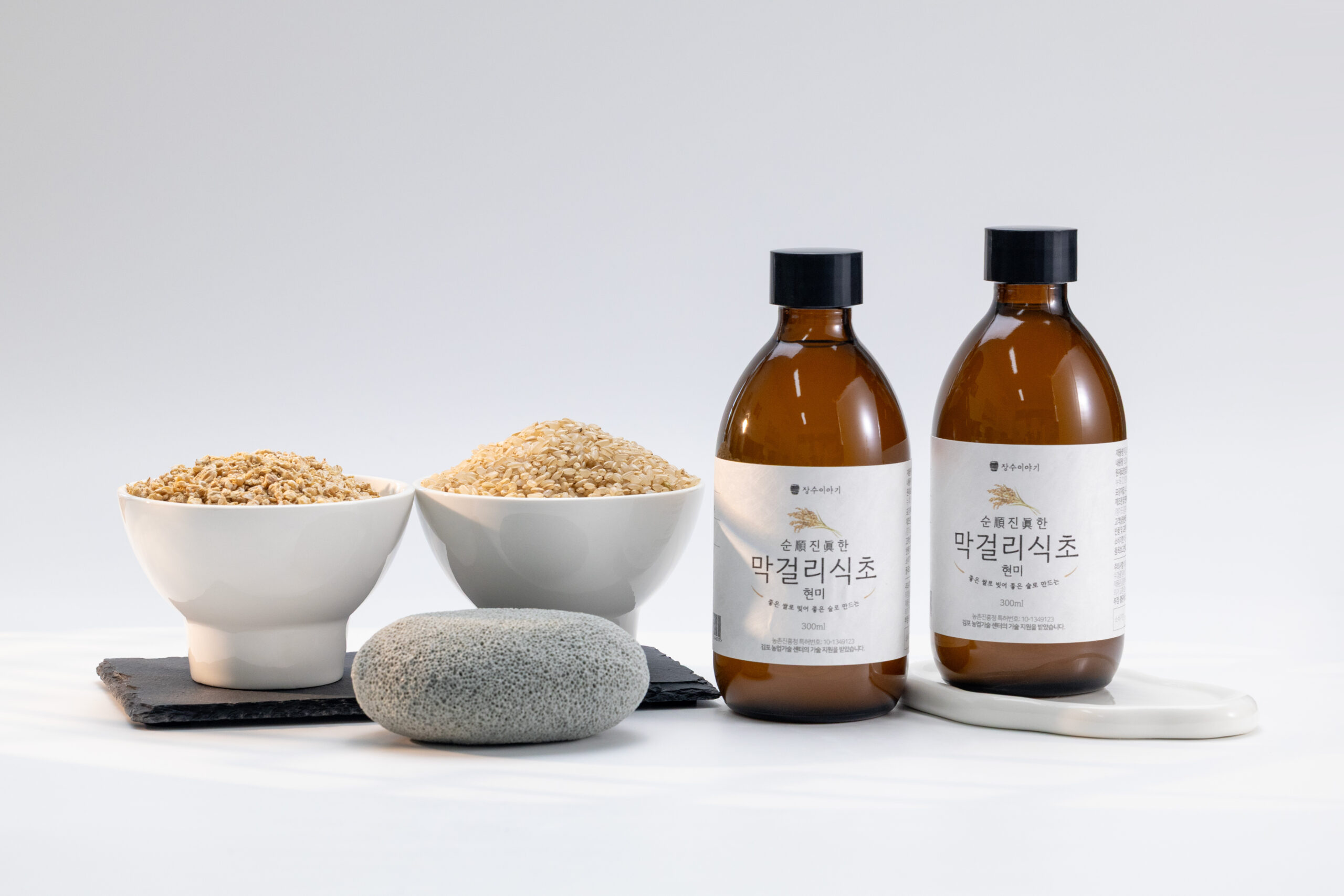 Makgeolli vinegar with brown rice bowls on white
