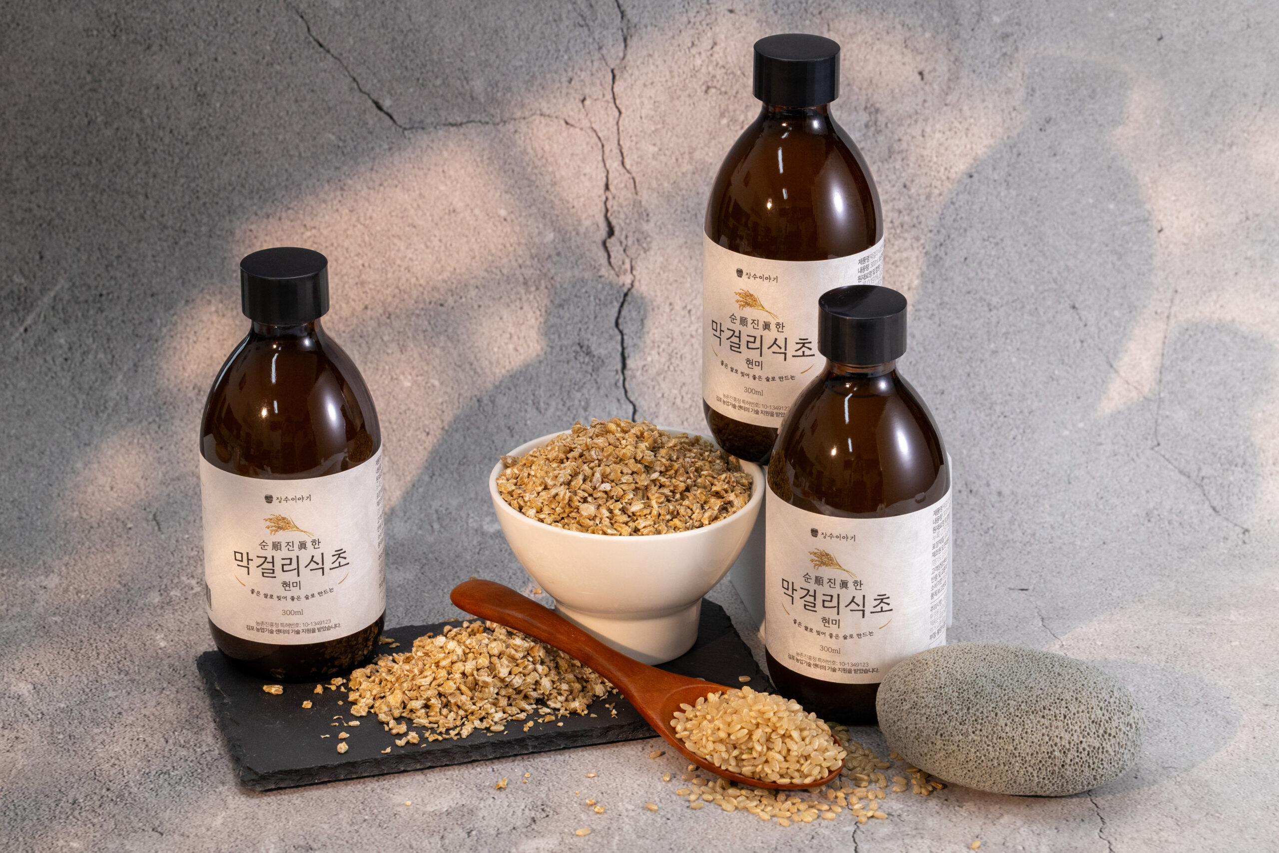 Three bottles of makgeolli vinegar on concrete